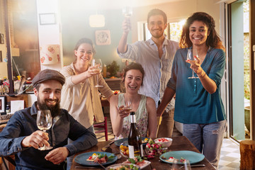 Mixed group of friends having fun while sharing a meal 