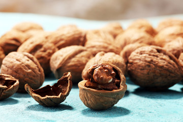 Walnut kernels and whole walnuts on rustic old table