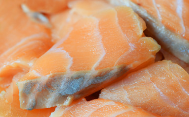 There are the pieces of salted fish close-up. It is texture from a salmon cut by segments.