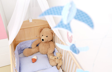 Ein großer und ein kleiner Teddybär sitzen in einem Kinderbett