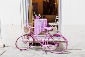 Fototapeta na wymiar vintage purple bicycle as decoration near cafe