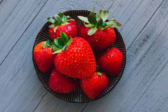 Centered Bright Red Strawberries on Blue Table