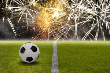 Photo sur Aluminium Foot Ballon de football sur la pelouse du stade devant les feux d& 39 artifice