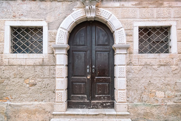 Entrance door of an ancient building in Porec town, Croatia, Europe.