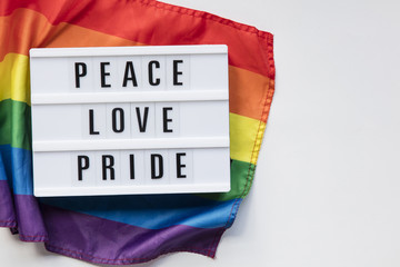 Peace love pride lightbox message on an LGBT gay pride flag