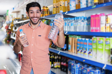 Happy man customer is choosing bottle with water