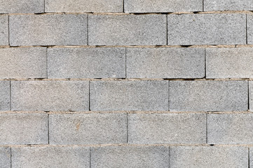 Spanish construction of a brieze-block wall showing bricks laid on a poor mortar bed but no interspacial mortar