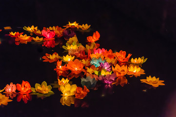 Paper lotus flowers with candles float on a river at night to mark the Chinese Mid-Autumn Festival