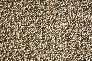 Fragment of an outdoor coating made of grey scabrous sand, closeup. Abstract grainy textured background.