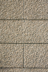 Fragment of an outdoor coating made of grey scabrous sand, closeup. Abstract grainy textured background.