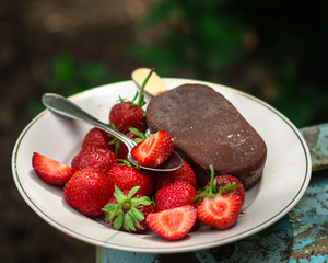 strawberry with ice cream. A portion of red berries and ice cream in chocolate. food background