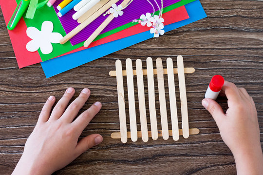 Colored paper, glue, sheets, ribbons, flowers for making a gift summer flowers on wooden sticks fence. Handmade. Project of children's creativity, handicrafts, crafts for kids.