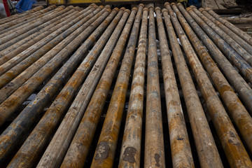 Oil drill pipe. Laid out drilling pipes at a well site.Well Drilling.Drill Pipe Stacked on Pipe Deck. Oil drill pipe. Laid out drilling pipes at a well site.Well Drilling.Drill Pipe Stacked