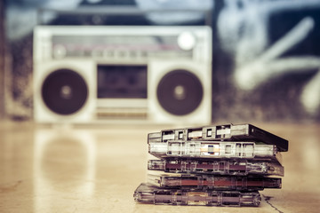 Pile of audio cassettes with vintage tape boombox / Audio cassettes stacked and placed on the...