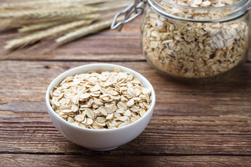 Dry rolled oat flakes oatmeal on wooden table