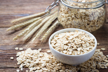 Dry rolled oat flakes oatmeal on wooden table