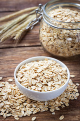 Dry rolled oat flakes oatmeal on wooden table