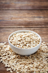 Dry rolled oat flakes oatmeal on wooden table