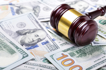 Wooden judge gavel on hundred dollar banknotes background
