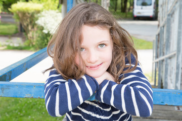 beauty child girl leaning on the blue balustrade of the hut