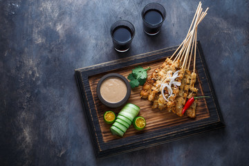 Chicken Satay or Sate Ayam - Malaysian famous food. Is a dish of seasoned, skewered and grilled meat, served with a peanut sauce. Top view copyspace