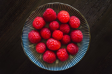 Bowl of Raspberries on Dark Table