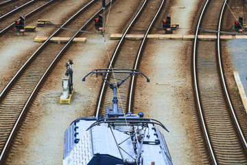 Electric locomotive and a train standing on the railroad tracks