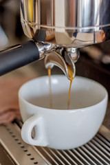 espresso flows from coffee machine