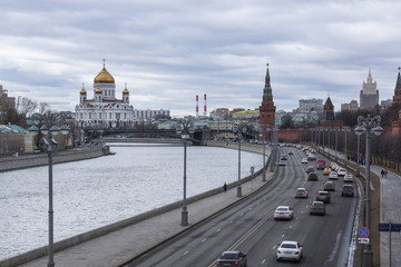 Moscow river bank with a daily car traffic and the famous orthodox cathedral on a background.