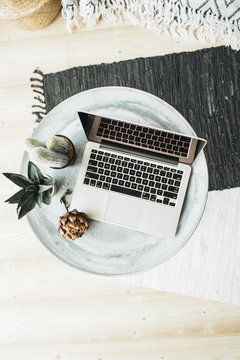 Laptop, protea flower and succulent on tray. Flat lay, top view still life hero header concept.