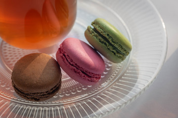 Colorful macarons on a transparent plate.