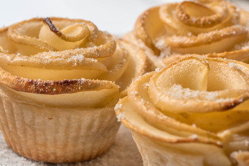 Puff pastry apple tarts made in the form of roses, powdered sugar on top.