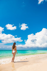 Fototapeta na wymiar Beach vacation travel luxury swimsuit woman relaxing on summer holidays with copy space ocean, white sand and blue sky paradise landscape background.