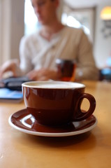 Coffee cup with man in background