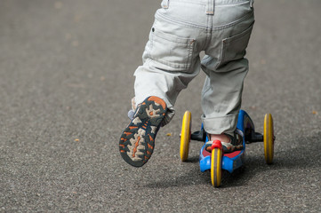 closeup of little boy on scooter in the street on back view