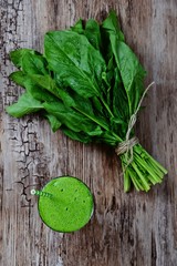 Green spinach smoothie isolated. Holding glass of spinach smoothie