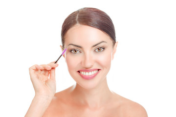 woman holding mascara brush near her long eyelashes