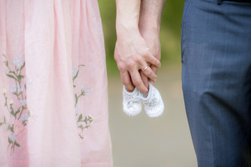 Happy and young pregnant couple hugging in nature - Detail of young pregnant couple - New Family