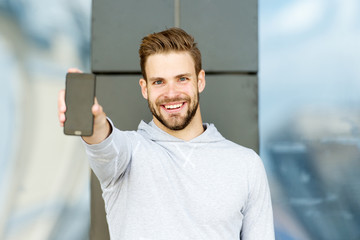 Showing his brand new smart phone. Man beard with smartphone, urban background. Man with beard...