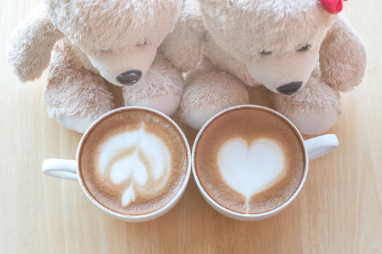 Top viwe of two teddy bears and coffee cup on pine wooden table.