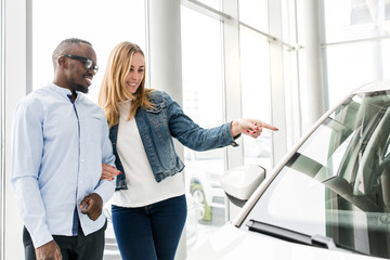 Girl shows her boyfriend liked the car in the dealership