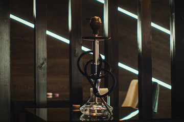 A beautiful glass hookah in a cafe on the table