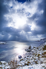 Norwegian Destinations. Picturesque View of Sunlight Going Through The Clouds Before the Sunset at Lofoten Islands in Norway.