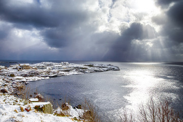 Norwegian Destinations. Picturesque View of Sunlight Going Through The Clouds Before the Sunset at Lofoten Islands in Norway.