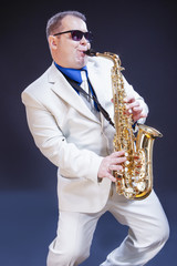 Portrait of Caucasian Expressive Mature Playing Saxophonist Against Black Background.