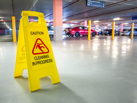 Warning janitorial sign of cleaning in progress in car park to warn passersby for safety.