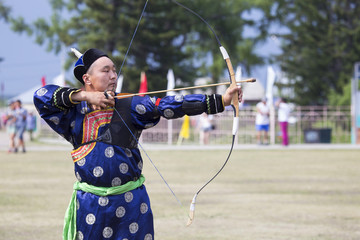 Young man shoots from a sports bow