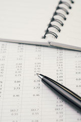 Financial stock, mutual fund or investment data, searching for yield concept, black pen on table and list of numbers with notebook on desk