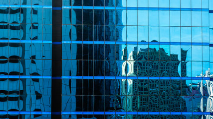 Blue sky and tower shadow reflected in the glass building.