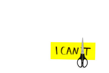 I can concept. Motivate youself, believe in yourself. Sciccors cut the letter t of written word I can't. White background top view copy space